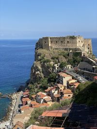 High angle view of buildings by sea against sky