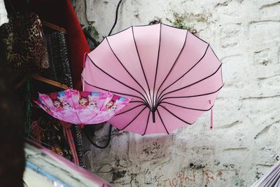 Close-up of pink umbrella against wall