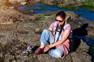 Portrait of young woman sitting on rock