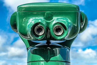 Low angle view of coin-operated binoculars against sky