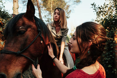 Woman standing with horse an friend