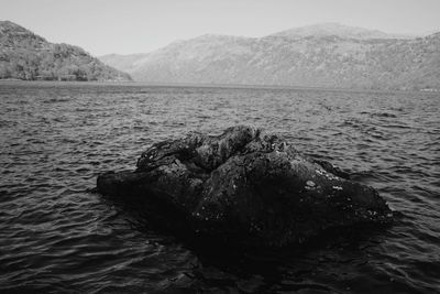 Rock formation amidst sea against mountain