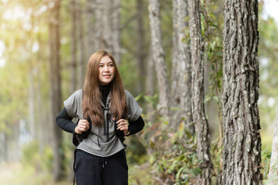 Young woman standing in forest