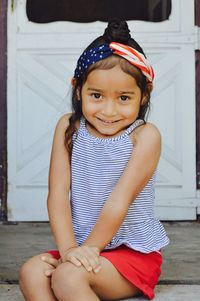 Portrait of smiling girl sitting outdoors