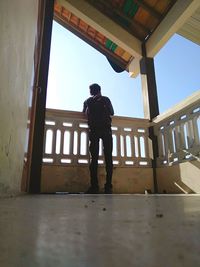 Low angle view of man standing by window in building