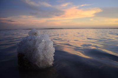 Close-up of sea against sky at sunset