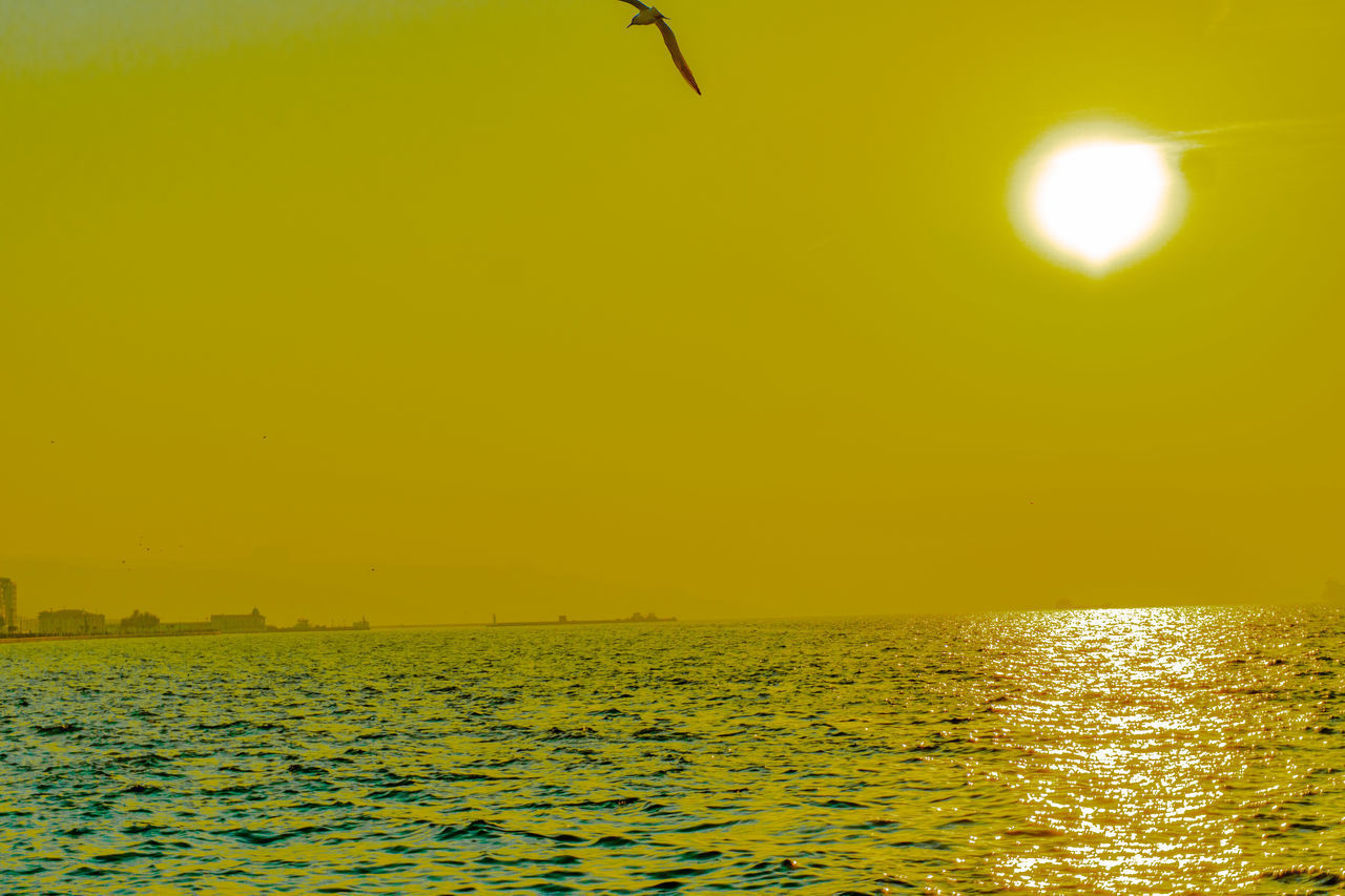 SCENIC VIEW OF SEA AGAINST YELLOW SKY