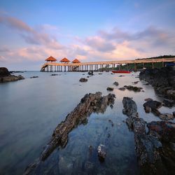 View of bridge over sea against cloudy sky