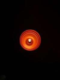 Low angle view of illuminated light bulb against black background