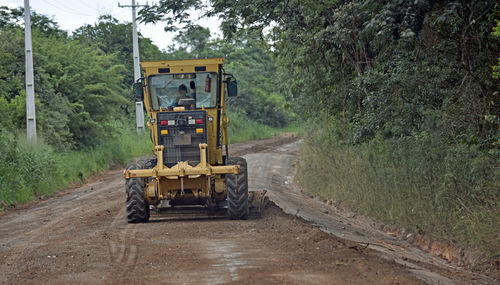 Tractor on dirt road in forest