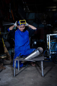 Portrait of young woman standing in factory