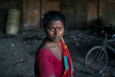 Portrait of young woman standing against abandoned outdoors