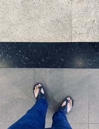 Low section of man standing on tiled floor