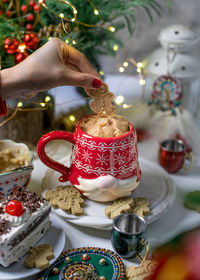 Cropped hand of woman holding christmas decorations