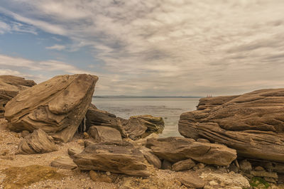 Scenic view of rocks on beach against sky