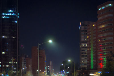 Low angle view of illuminated buildings against sky at night