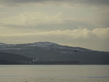 Scenic view of sea and mountains against sky