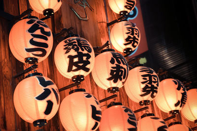 Low angle view of text on illuminated lanterns at night