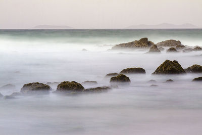 Rocks in sea against sky