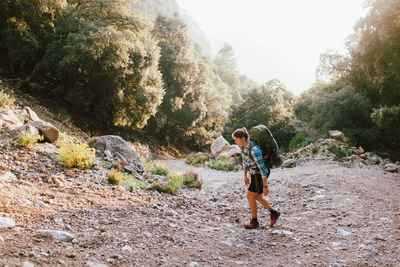 Woman standing on rock against trees
