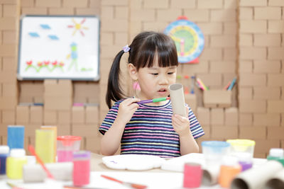 Portrait of young girl making craft for home schooling