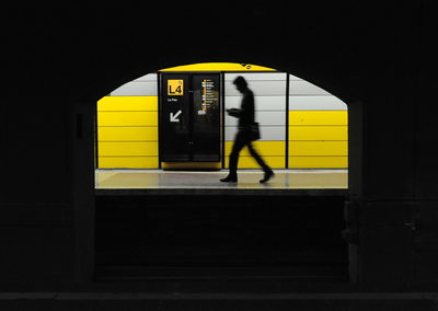 Silhouette man standing in yellow train