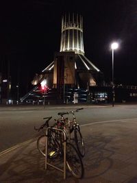 Bicycles against illuminated street lights in city at night