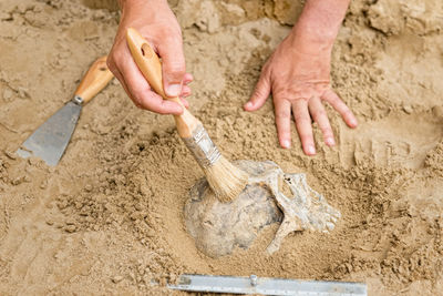 Close-up of hands working on sand