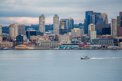 View of buildings by sea against sky