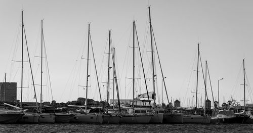 Boat masts in row in a sunny day.in black and white.