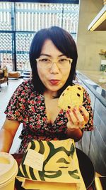 Portrait of woman holding ice cream in restaurant