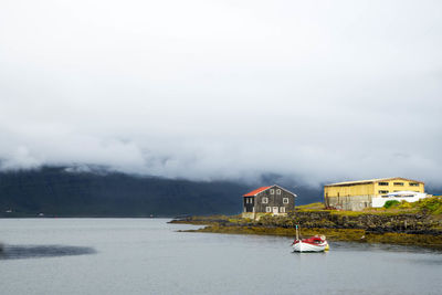 Scenic view of lake by buildings against sky