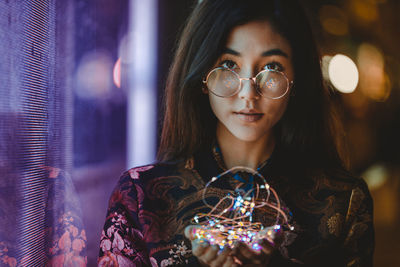 Portrait of woman with illuminated lighting equipment