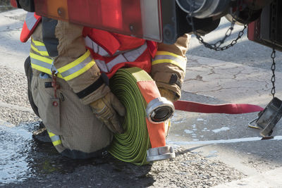 Low section of firefighter rolling hose by firetruck