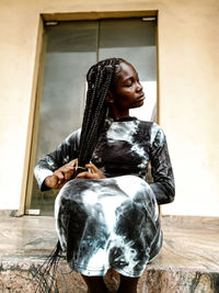 Portrait of young woman sitting on table