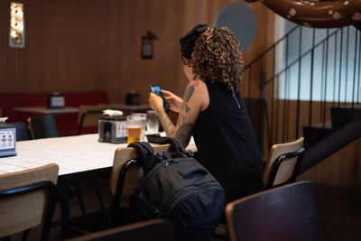 Midsection of woman holding coffee while sitting on table