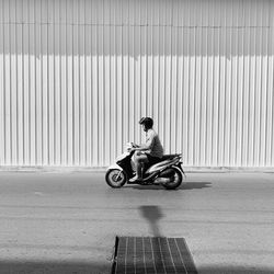 Side view of man sitting on motor scooter
