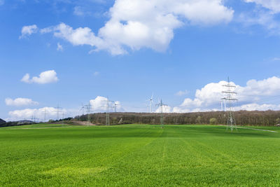 Electricity pylon on field against sky