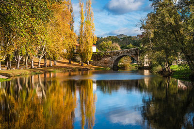 Arch bridge over lake against sky