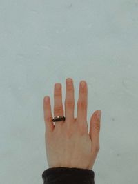 Close-up of hand against wall