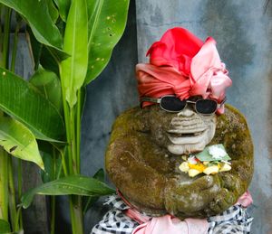 Close-up of statue with red flower