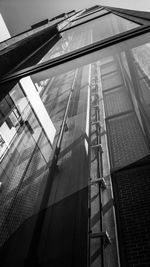Low angle view of glass building against sky