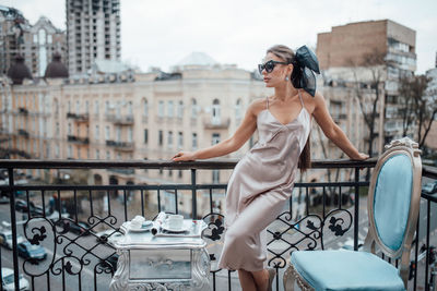 Full length of woman on railing in city