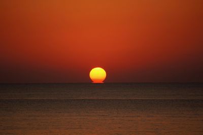 Scenic view of sea against orange sky