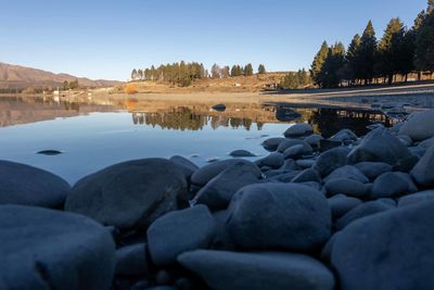 View of rocks in lake against sky