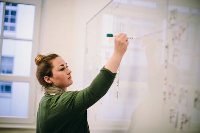 Side view of woman standing against wall