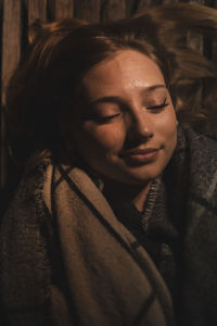 Close-up of smiling young woman with eyes closed