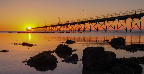 Bridge over river against sky during sunset