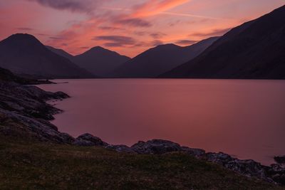 Scenic view of lake and mountains against sky during sunset