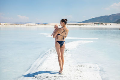 Full length of young woman standing on beach